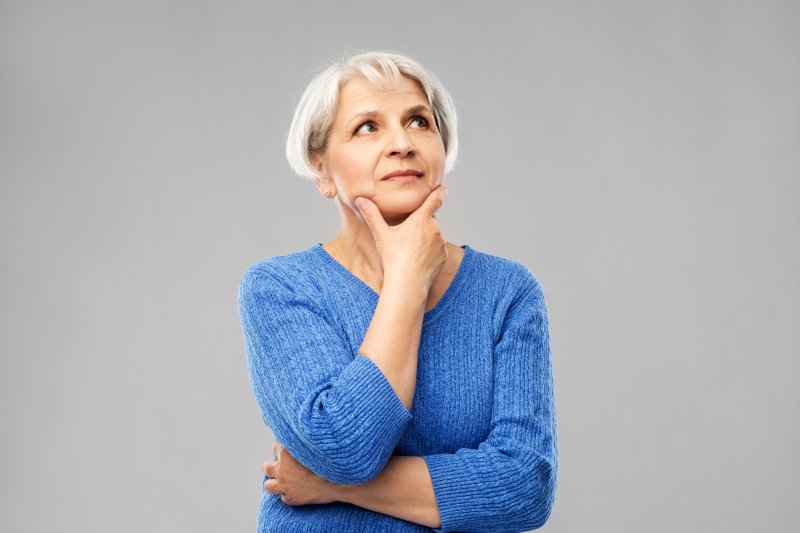 Woman in a questioning pose on a grey background