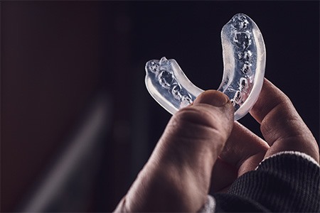 Close-up of hand holding a mouthguard