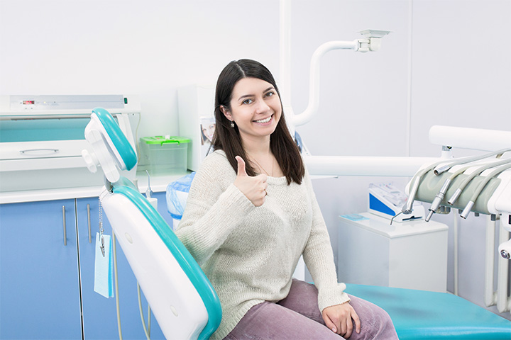 Female dental patient giving a thumbs up