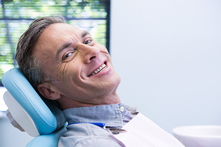 Man sitting back in dental chair and smiling