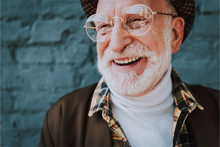 Stylish man smiling with blue bricks in the background