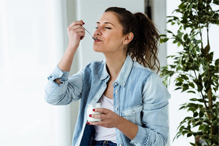 Woman enjoying a spoonful of yogurt
