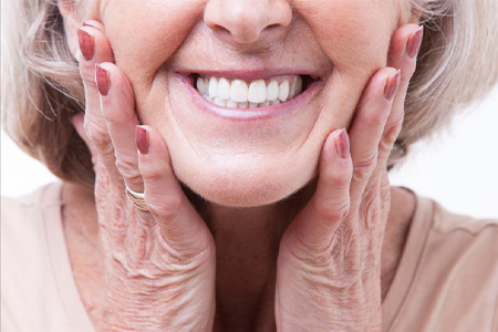 Woman pressing her hands to her face as she smiles