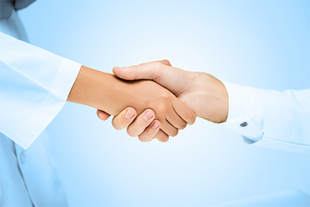Close-up of dentist and patient shaking hands