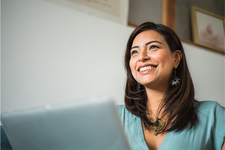 A smiling woman with a laptop in her lap