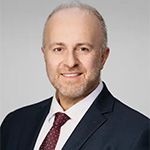 Profile image of Dr. Konstantinos Vazouras smiling in a suit and tie.