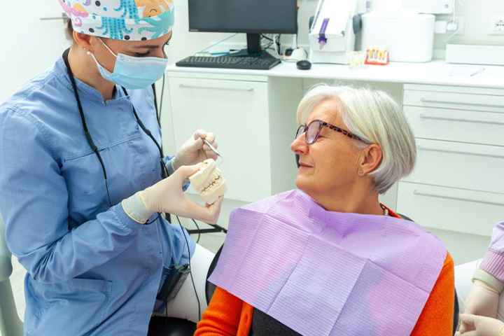 Senior patient talking with dentist during consultation.