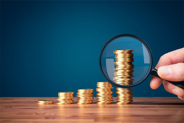Coins examined with magnifying glass.
