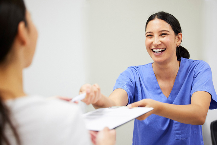 Dental receptionist explaining the cost of Invisalign to patient.