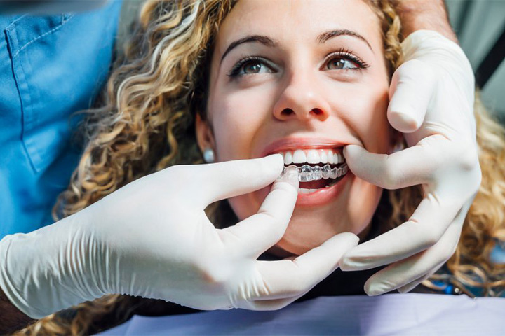 Dentist checking Invisalign fit during an appointment.