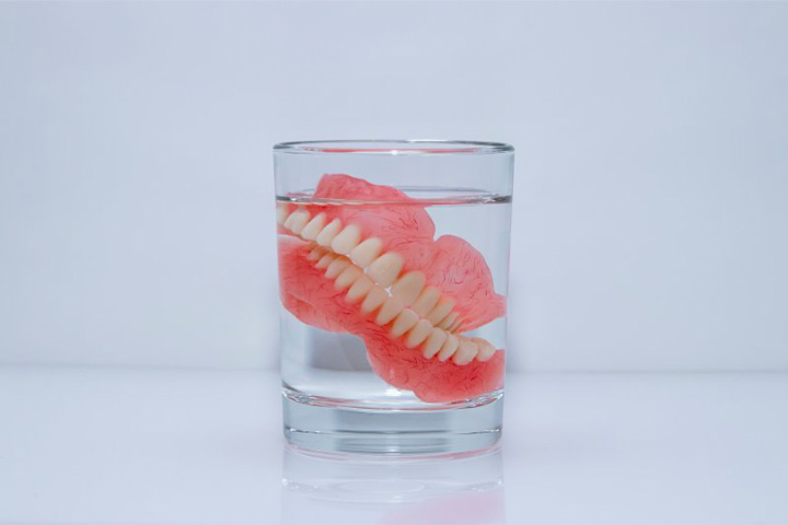 Dentures soak in clear liquid.