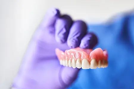 Full upper denture in person’s hand.