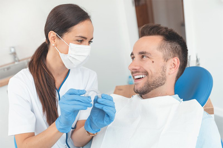 Male patient seeing dentist about Invisalign aligners.