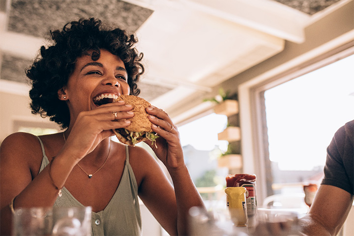 Woman eating a meal as part of the benefits of Invisalign in Chelmsford.