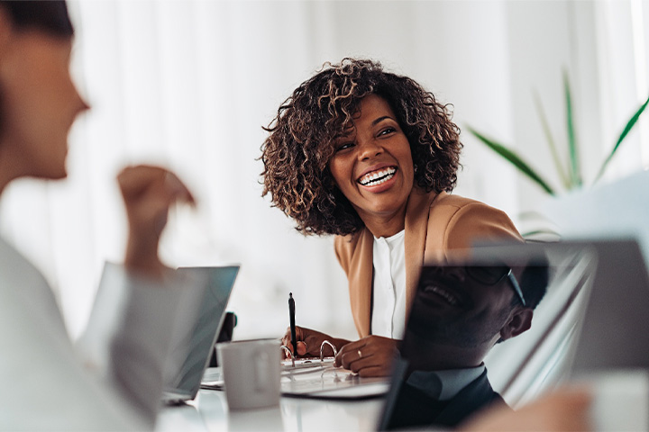 Young woman smiling at work while wearing an Invisalign aligner in Danvers.